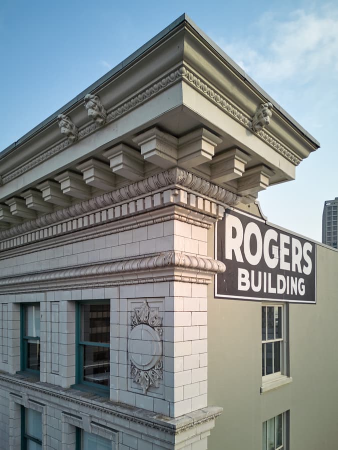 Close view of the Rogers Building cornice with lion heads and dentils